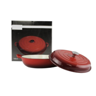 cratiță joasă din fontă pentru cuptor cu capac așezată în fața cutiei în care este ambalată